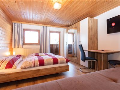 Dormitorio para varias personas con balcón.