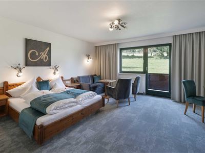 La espaciosa habitación Wilder-Kaiser ofrece dos camas, un pequeño rincón de estar y una ventana con vistas al verde. La decoración es moderna y acogedora.