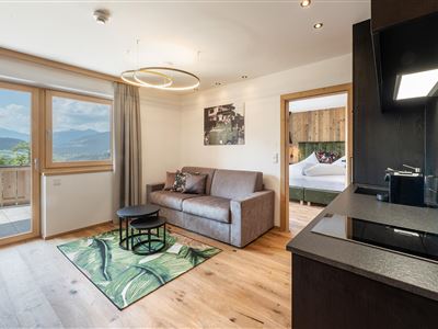 La Suite Salven encanta con su moderno salón, sofá, sensación de espacio abierto, mucha luz natural y vistas de ensueño a las montañas tirolesas: su elegante oasis de vacaciones.