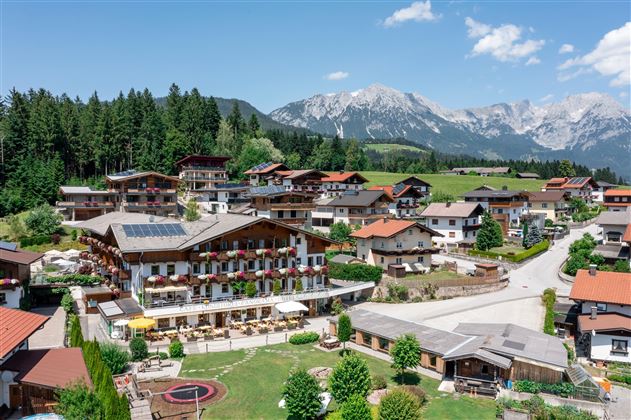 Vista aérea del Hotel Alpenpanorama con paisaje montañoso y terraza soleada.