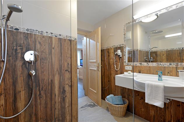 Baño luminoso en el Hotel Alpenpanorama en la región turística Wilder Kaiser con ducha, lavabo y detalles de alta calidad.