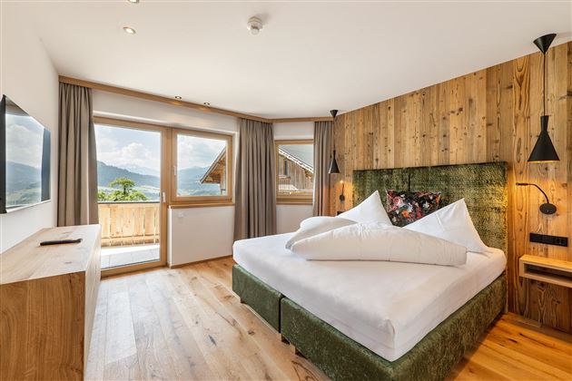 Vivir con sensación de naturaleza: La acogedora "Salven-Suite" decorada con cariño, con mucha madera, una gran cama y vistas panorámicas, combina comodidad y diseño.