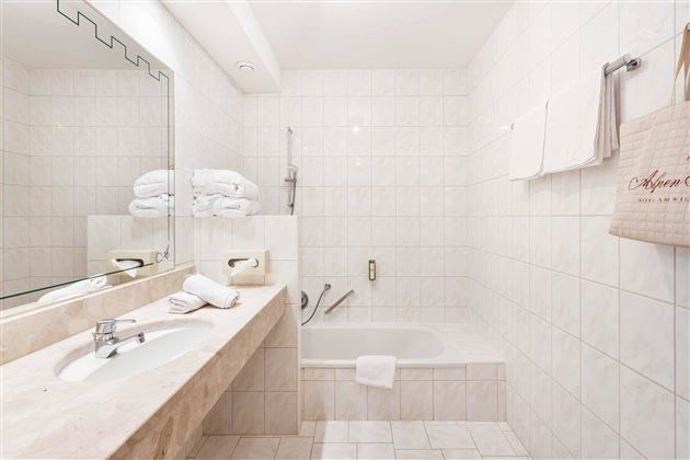 Fresco en el día: El baño luminoso con un amplio espejo, lavabo doble y bañera proporciona bienestar y comodidad.