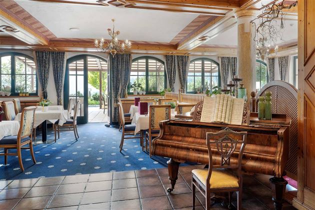Un toque de nostalgia: El elegante comedor con piano y una decoración estilizada ofrece noches placenteras en un ambiente especial.