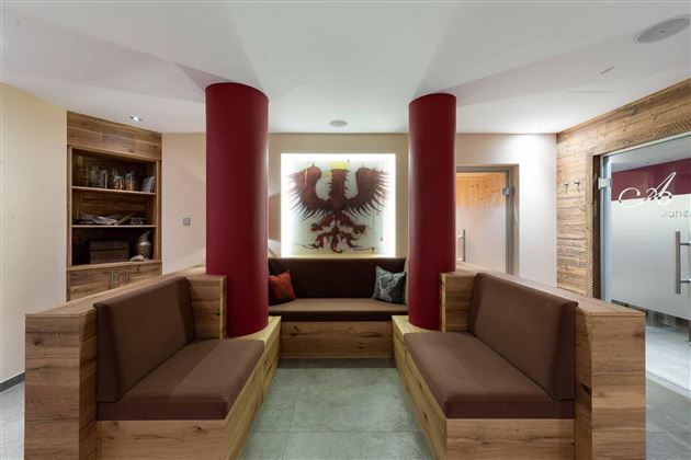Área de descanso acogedora con cómodos asientos, elementos de diseño elegantes y una armoniosa combinación de colores – perfecta para relajarse después de una sesión de sauna.