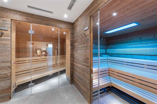 Bienestar puro en el AlpenSchlössl: En la moderna sauna con un ambiente luminoso y un diseño en madera natural, relaja cuerpo y mente.