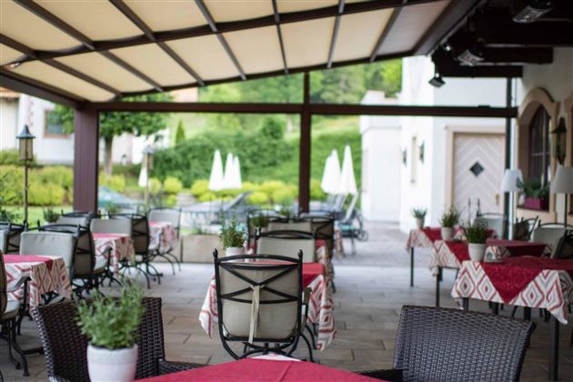 Disfrute al aire libre: En la acogedora terraza con vista al jardín, los huéspedes disfrutan de café, desayuno o una copa de vino en un ambiente relajado.