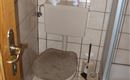 Ein kleines Badezimmer mit einer Toilette und einer Duschkabine. Die Wände sind gefliesen Toilet.
