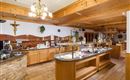 Zona de restaurante luminosa del Hotel Alpenpanorama con buffet, techo de madera y decoración tirolesa.