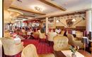 La acogedora zona de bar con elegantes sillones y decoración de mesa. Colores cálidos crean un ambiente acogedor.