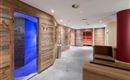 Bienestar con estilo: El área de sauna en el Hotel AlpenSchlössl combina un diseño de madera tradicional con una moderna decoración de color y luz para una experiencia de relajación integral.