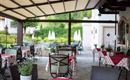 Disfrute al aire libre: En la acogedora terraza con vista al jardín, los huéspedes disfrutan de café, desayuno o una copa de vino en un ambiente relajado.
